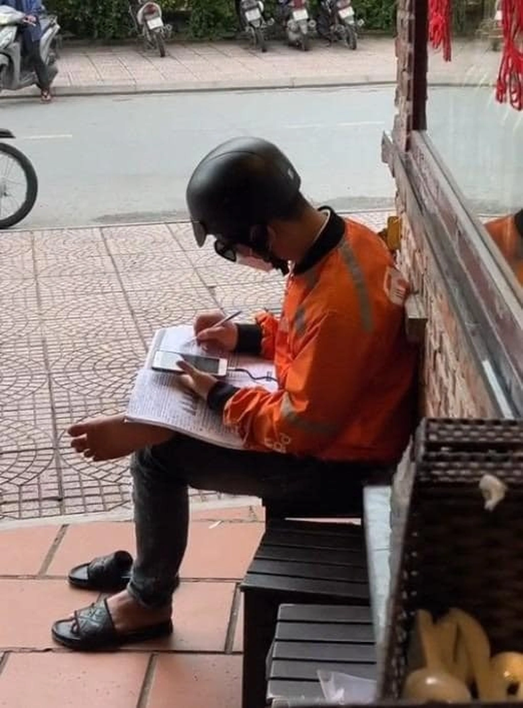 Nam sinh làm nghề giao hàng tranh thủ học tiếng Anh khi chờ giao 1